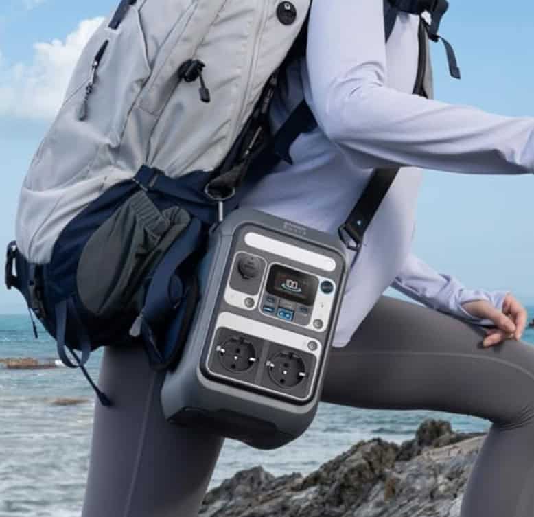 Person trägt tragbare Powerstation mit Tragegurt am Meer