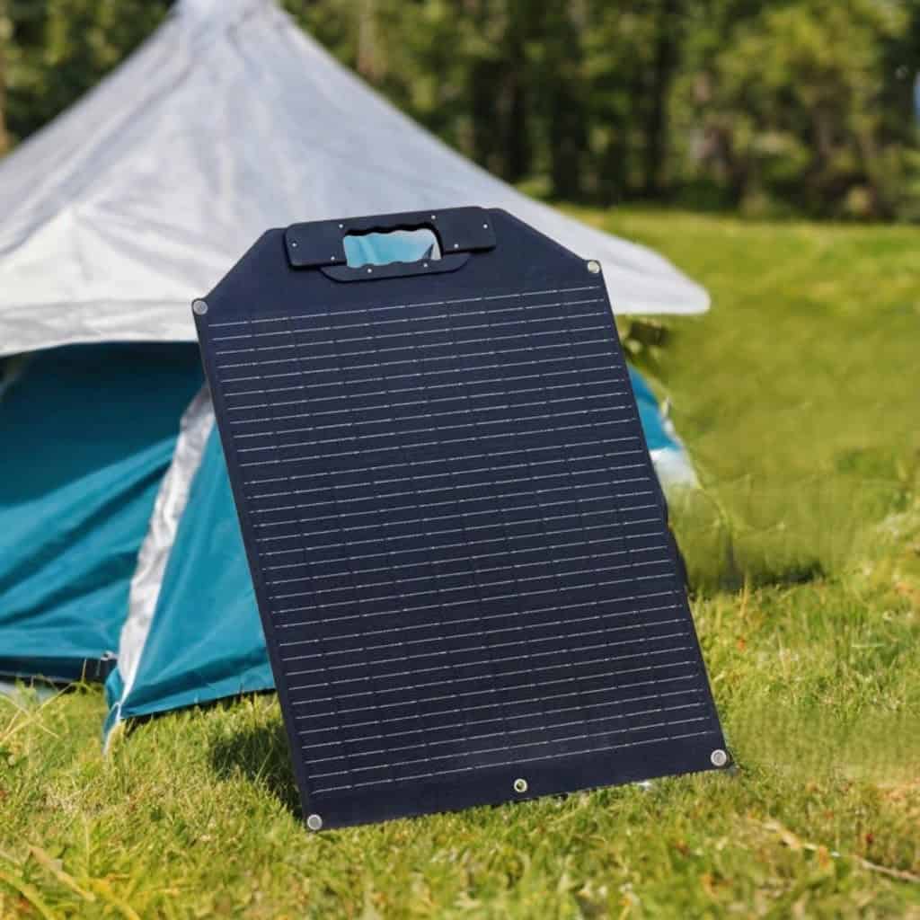 Maentum 50W faltbares Solarpanel steht aufgestellt vor türkisem Zelt auf grüner Wiese