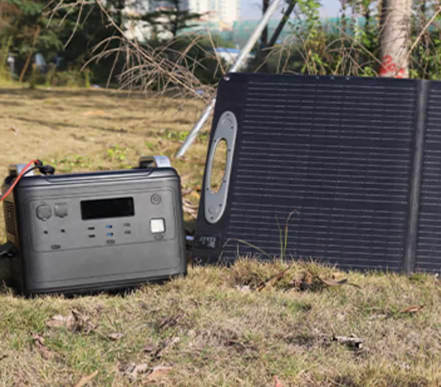 Powerstation mit angeschlossenem Solarpanel auf Wiese bei Outdoor-Einsatz