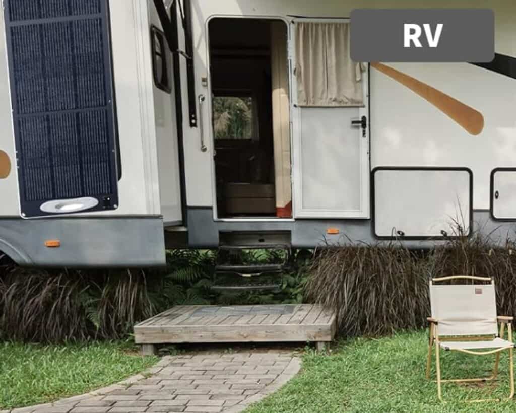 Solarpanel neben weißem Wohnmobil auf Campingplatz aufgestellt
