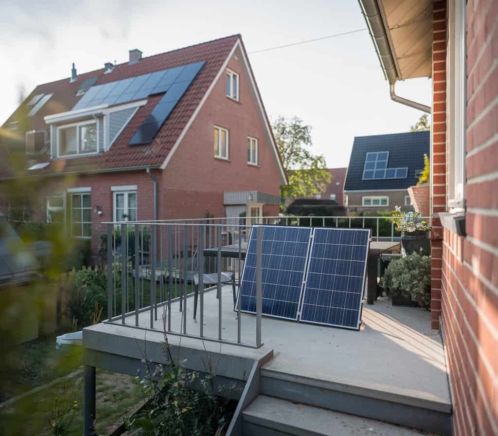 Faltbares Solarpanel steht auf einer erhöhten Terrasse eines Einfamilienhauses mit Solardach